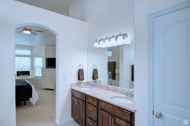 Bathroom featuring tile floors, double sink vanity, and ceiling fan