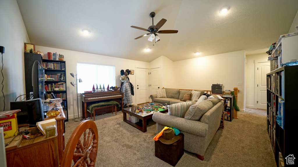 Carpeted living room featuring lofted ceiling and ceiling fan
