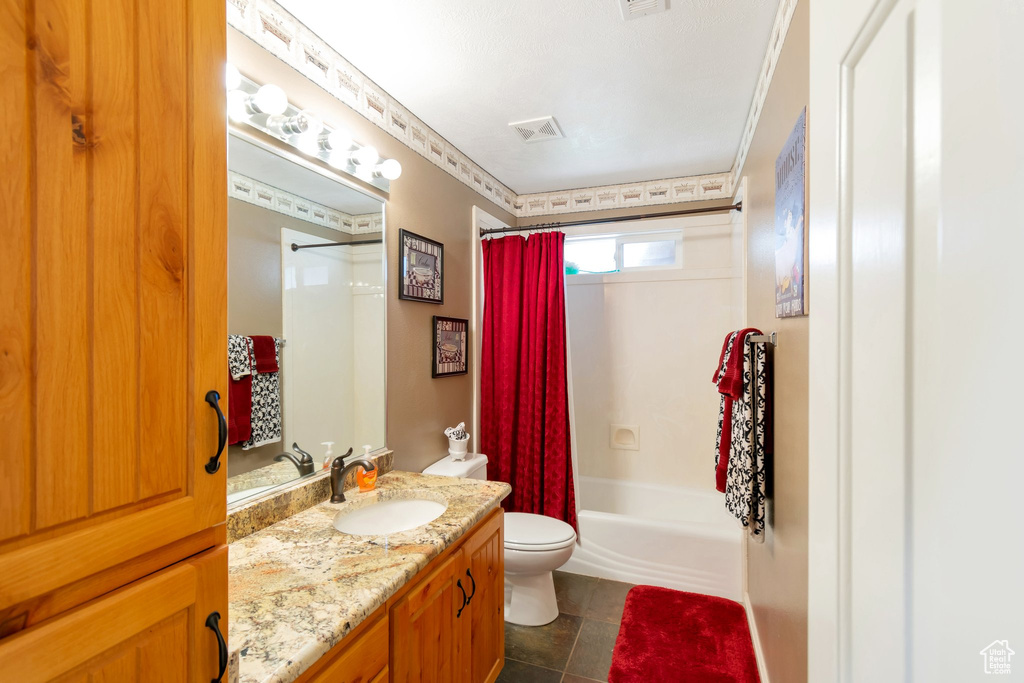 Full bathroom featuring tile floors, large vanity, toilet, and shower / bathtub combination with curtain