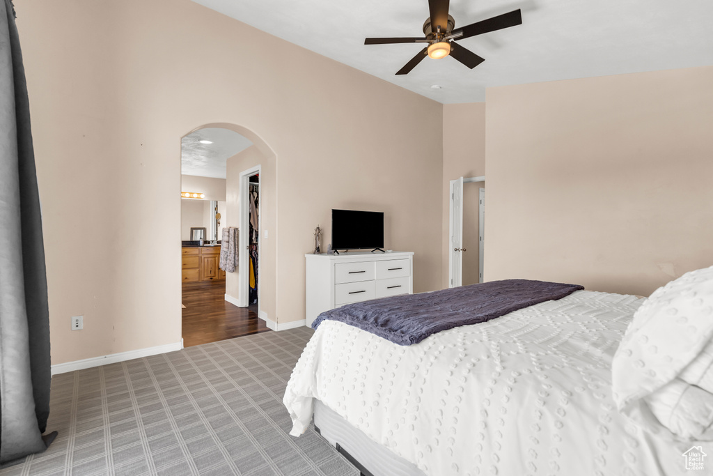 Bedroom featuring ensuite bathroom, light hardwood / wood-style flooring, and ceiling fan