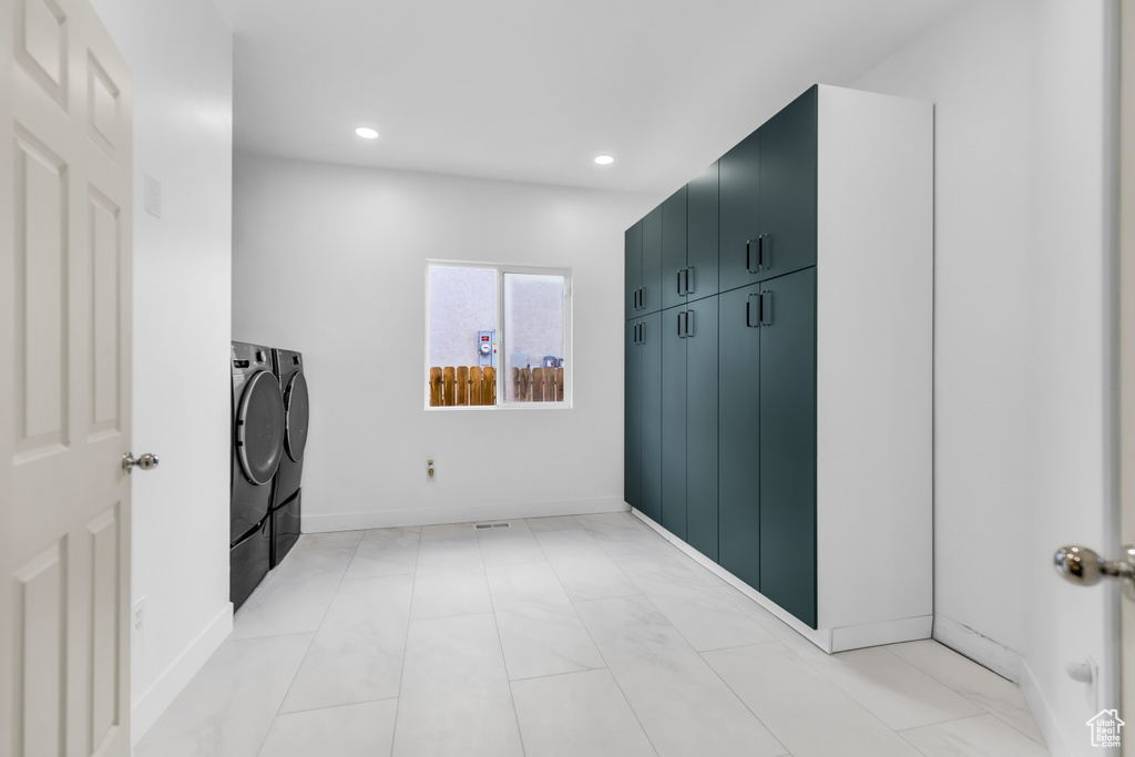 Mudroom with light tile flooring and separate washer and dryer