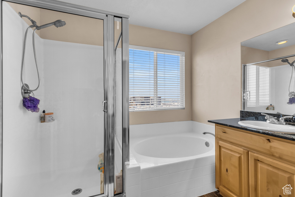 Bathroom featuring shower with separate bathtub and oversized vanity