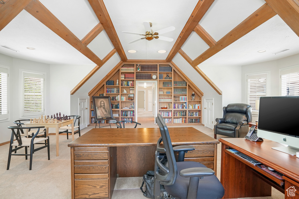 Carpeted home office with built in features, ceiling fan, and lofted ceiling with beams