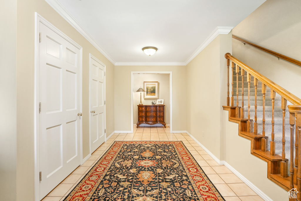 Hallway featuring crown molding and light tile floors