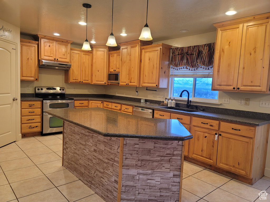 Kitchen with a kitchen breakfast bar, appliances with stainless steel finishes, a center island, light tile floors, and sink