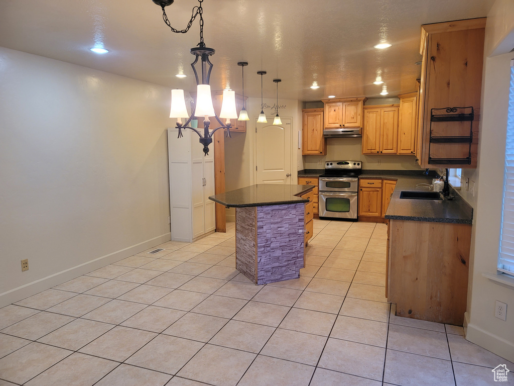 Kitchen with a kitchen island, light tile floors, double oven range, a chandelier, and sink