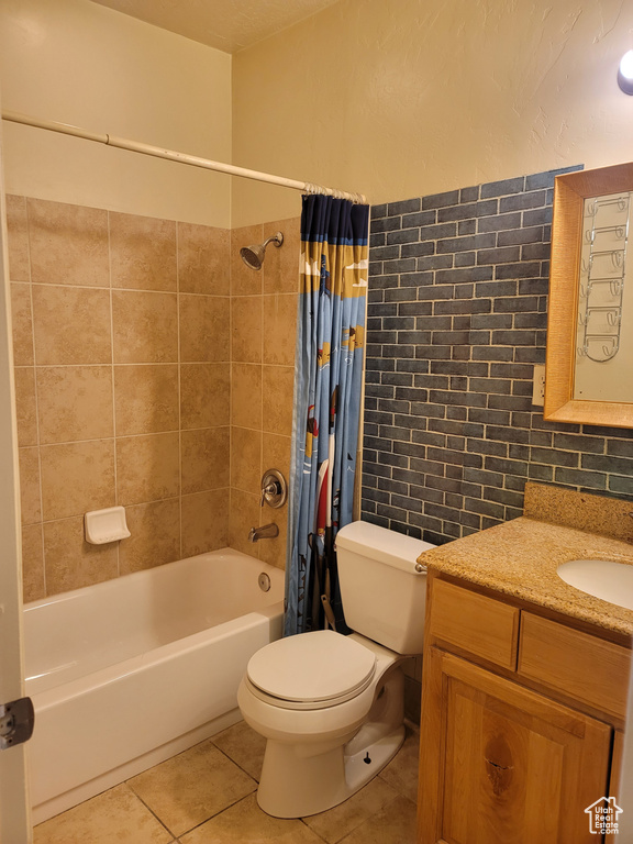 Full bathroom featuring shower / bath combination with curtain, toilet, vanity, tile walls, and backsplash