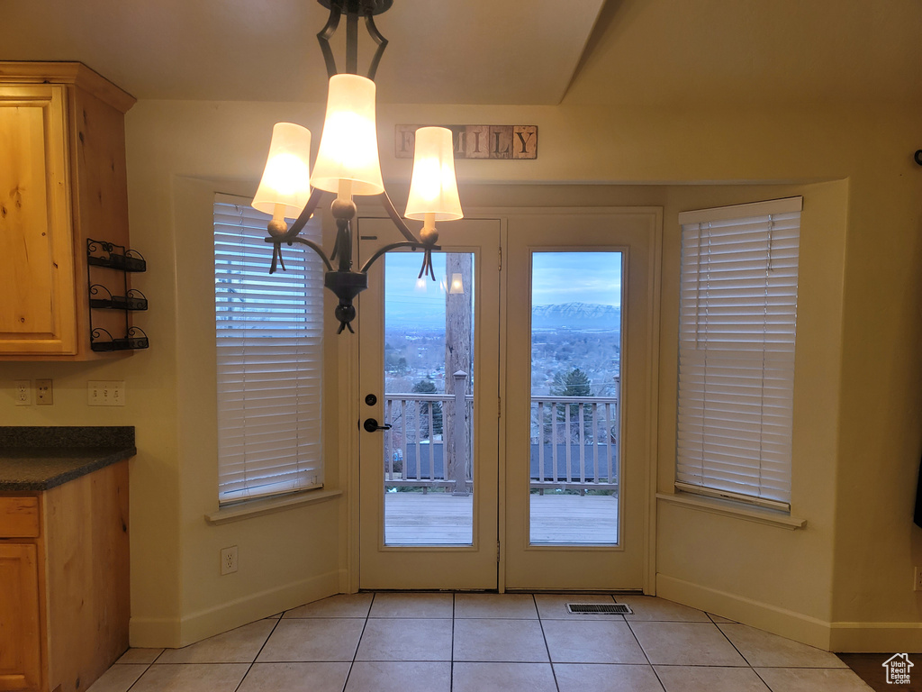 Entryway with a notable chandelier, a mountain view, and light tile flooring