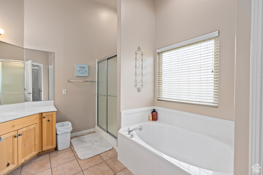 Bathroom with independent shower and bath, vanity, a towering ceiling, and tile flooring