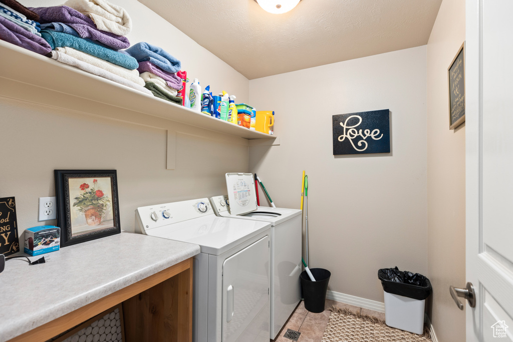 Laundry area featuring light tile flooring and washer and dryer