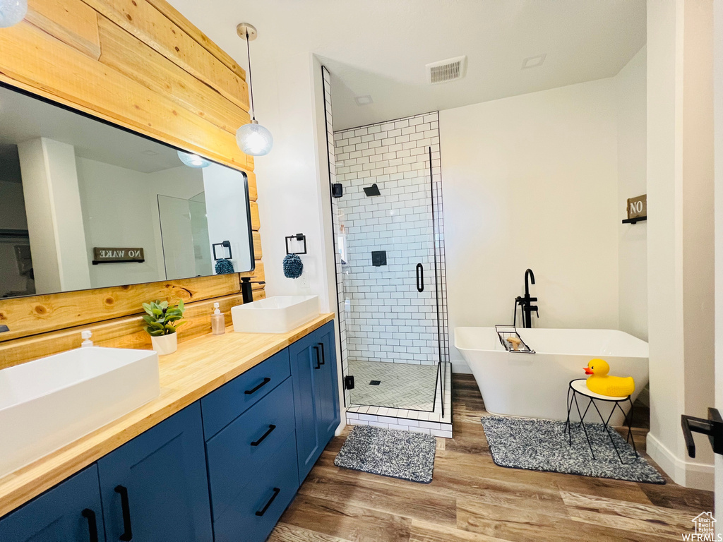 Bathroom with wood-type flooring, double sink vanity, and walk in shower
