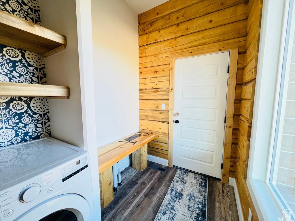 Laundry area featuring washer / dryer, wooden walls, and dark wood-type flooring