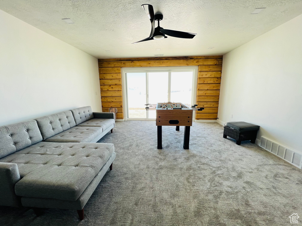 Rec room with light colored carpet, a textured ceiling, and ceiling fan