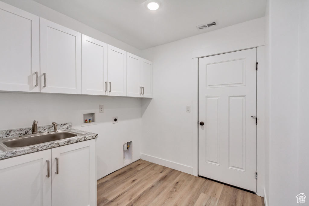 Laundry room with cabinets, electric dryer hookup, light hardwood / wood-style flooring, hookup for a washing machine, and sink