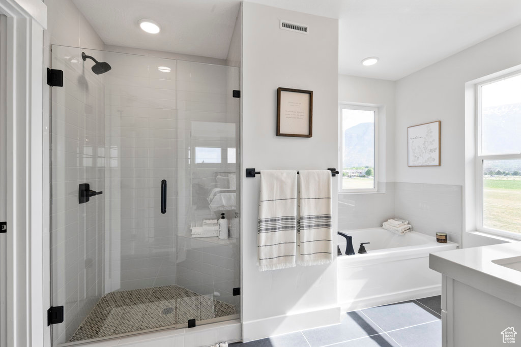 Bathroom with tile floors, vanity, and separate shower and tub