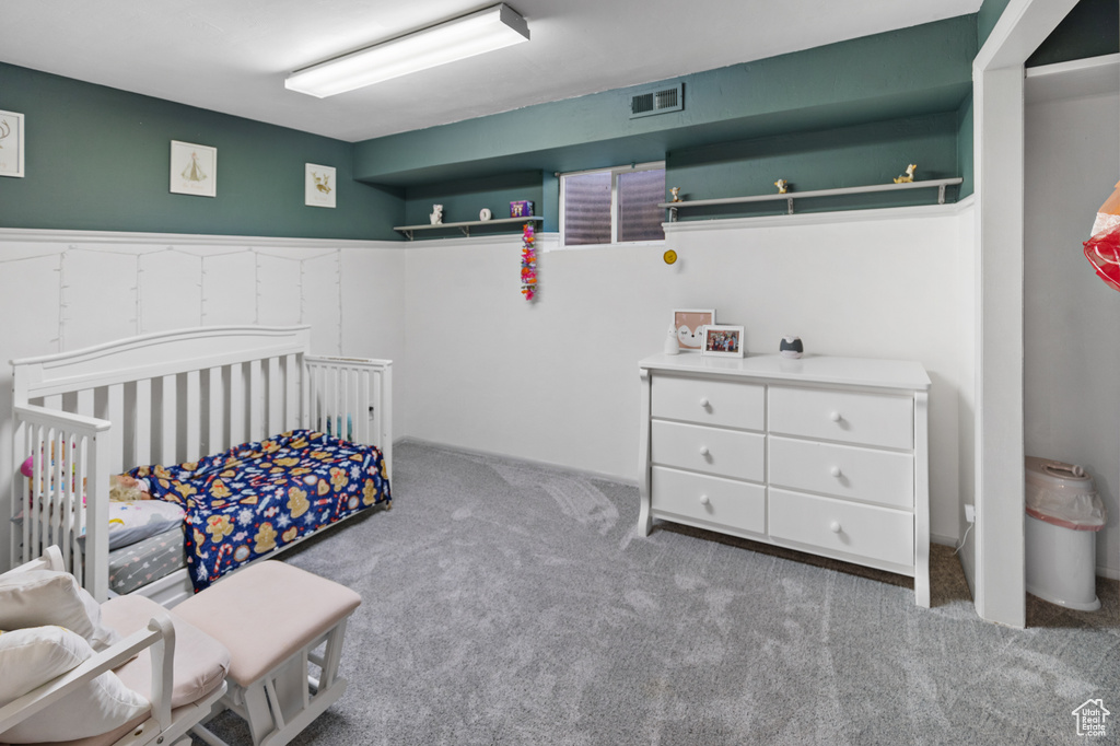 Bedroom with a nursery area and light colored carpet