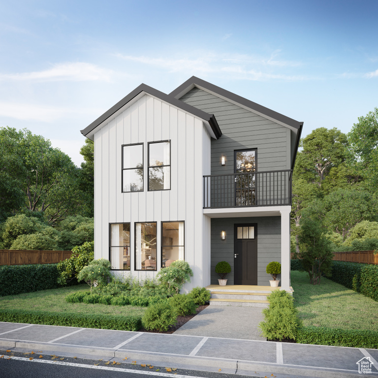 View of front of house with a front lawn and a balcony