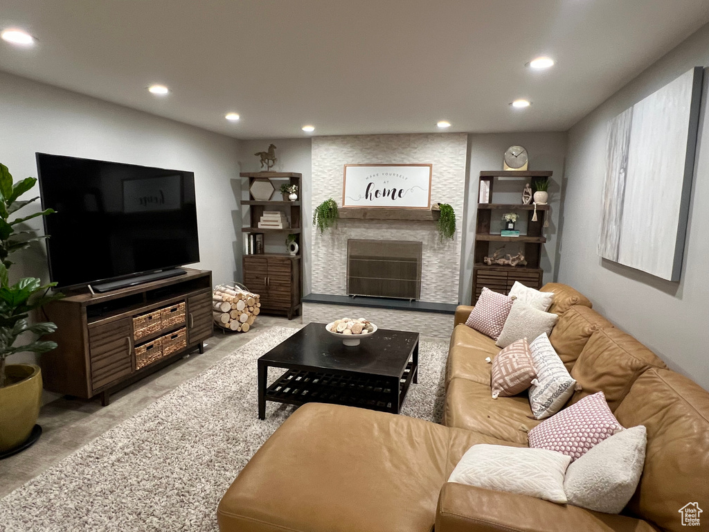 Living room with a stone fireplace and light colored carpet