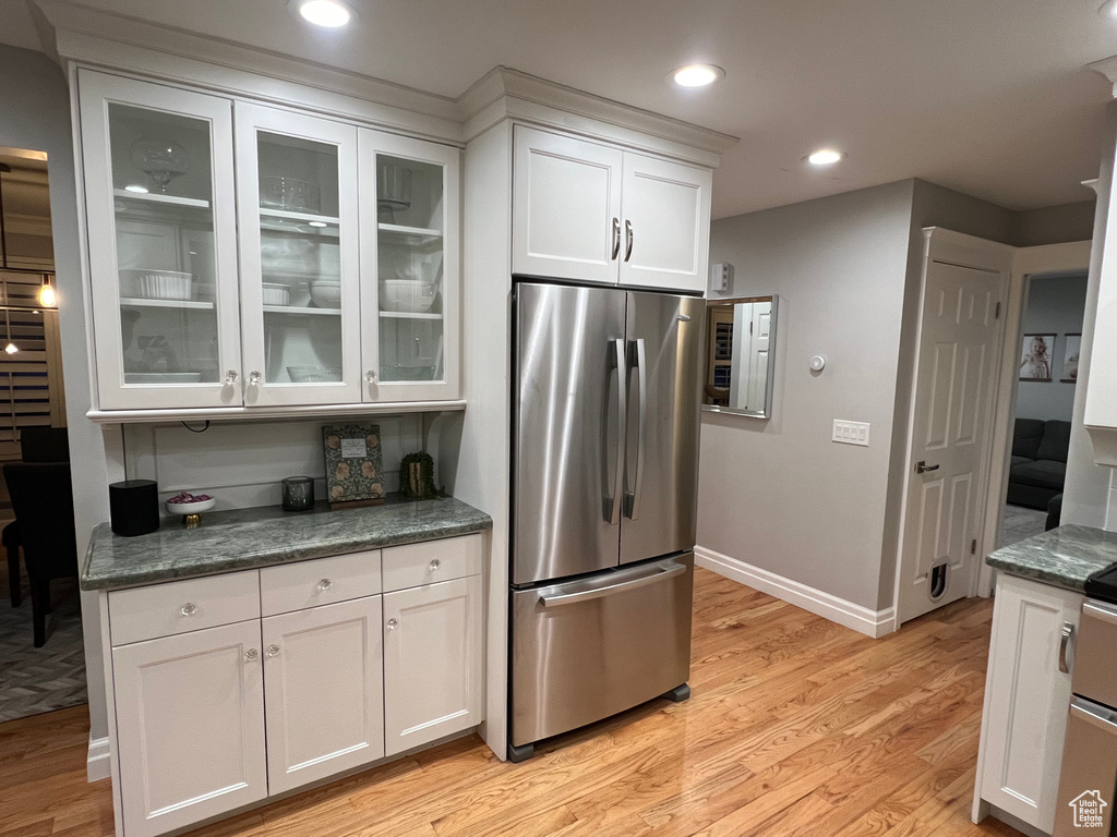 Kitchen featuring white cabinetry, stainless steel refrigerator, and light hardwood / wood-style flooring
