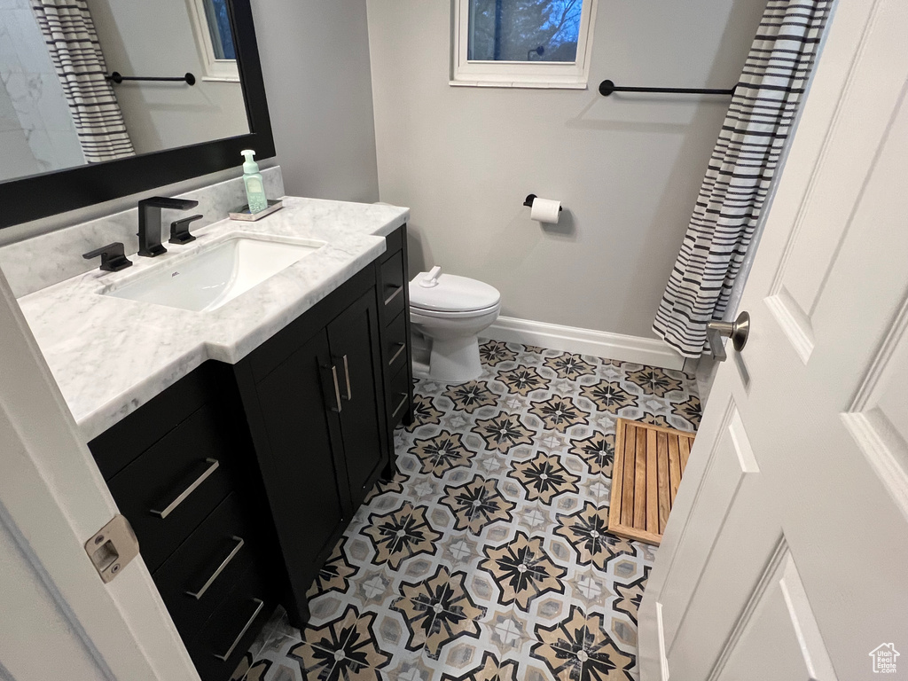 Bathroom with tile floors, toilet, and vanity with extensive cabinet space