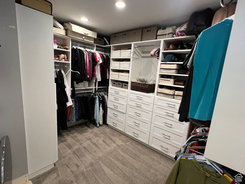 Walk in closet featuring light colored carpet