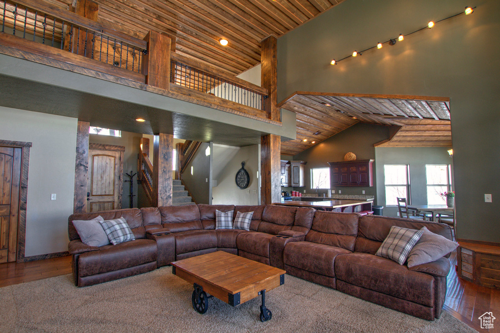 Living room featuring high vaulted ceiling, wooden ceiling, and hardwood / wood-style flooring