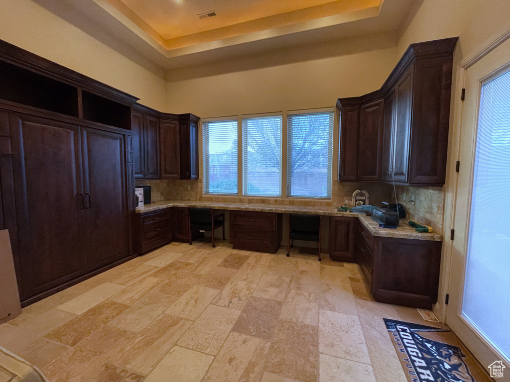 Kitchen featuring tasteful backsplash, a wealth of natural light, and light tile flooring