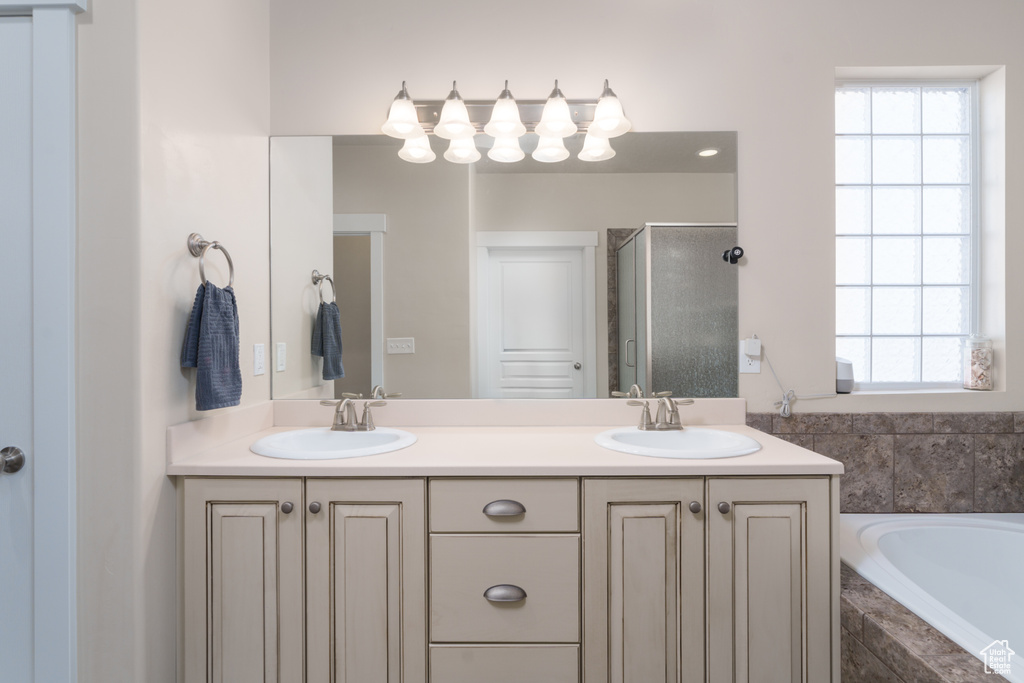 Bathroom with separate shower and tub, double sink vanity, and a healthy amount of sunlight