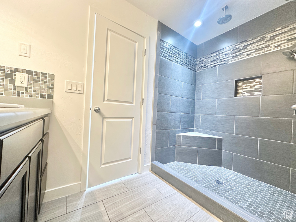 Bathroom with vanity, tile floors, and tiled shower