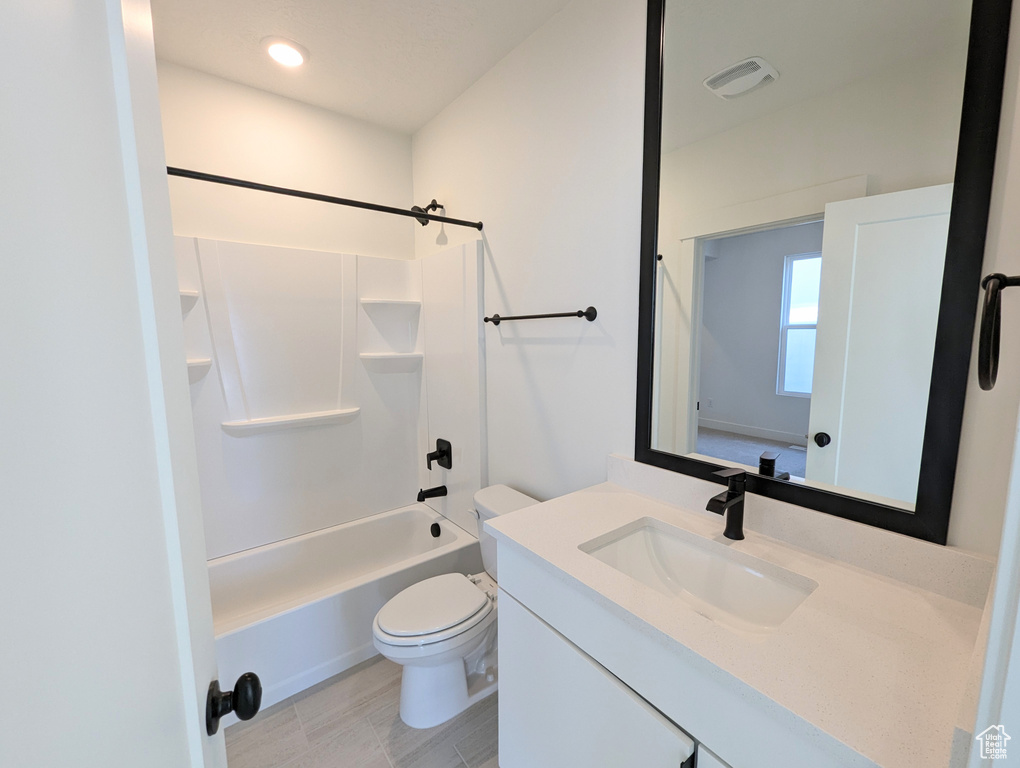 Full bathroom featuring toilet, tile floors, large vanity, and bathtub / shower combination
