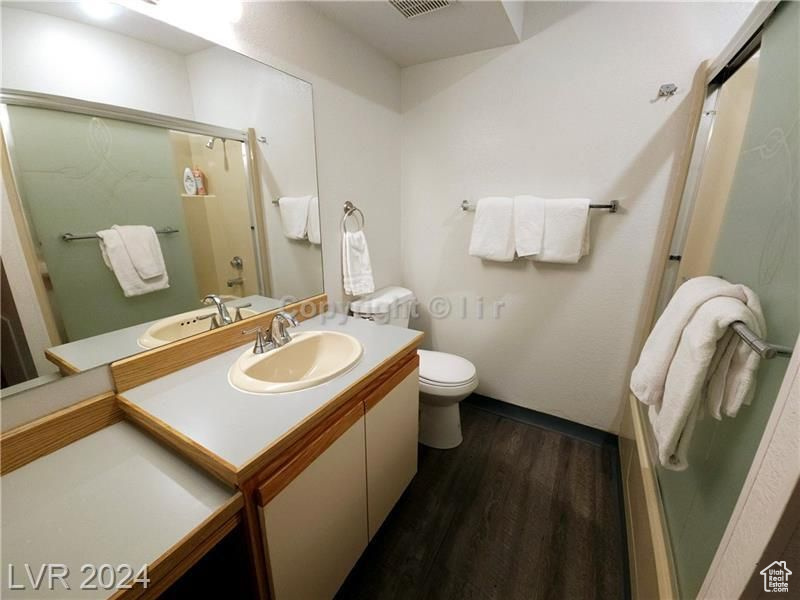 Bathroom with hardwood / wood-style floors, toilet, and vanity