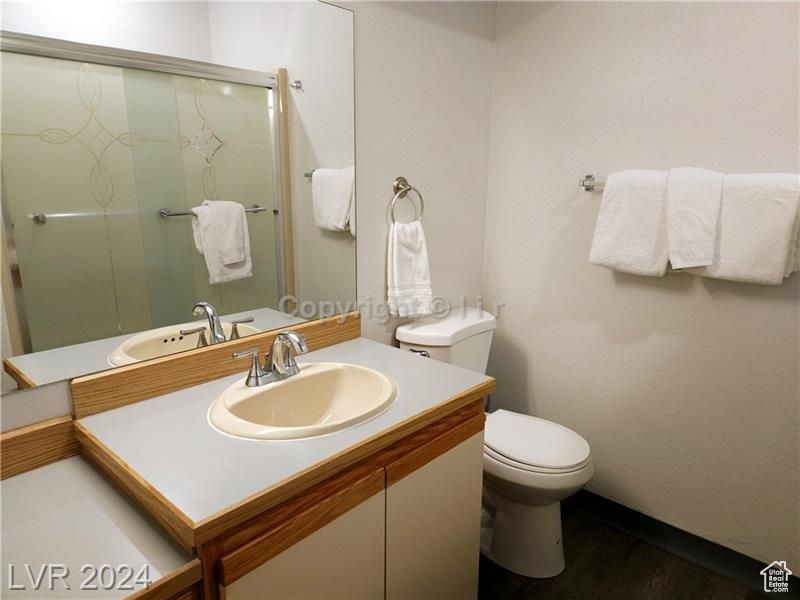 Bathroom with wood-type flooring, toilet, and large vanity