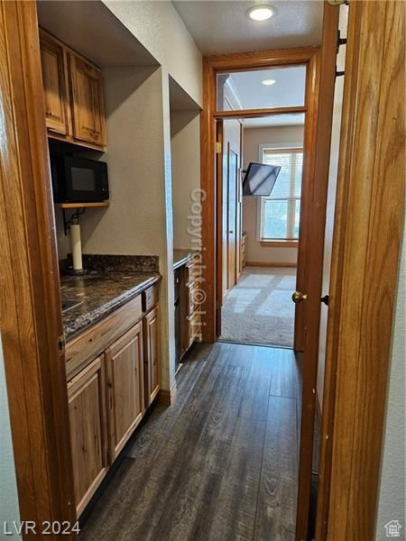 Hall with dark hardwood / wood-style flooring