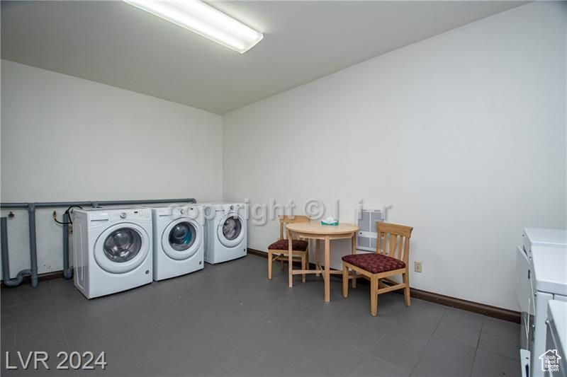 Laundry area with washer and clothes dryer and dark tile floors