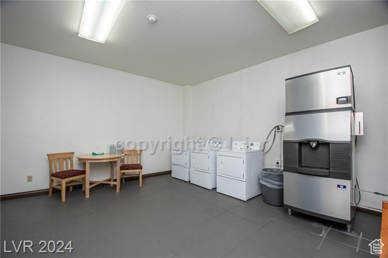Interior space with dark tile floors and washing machine and dryer