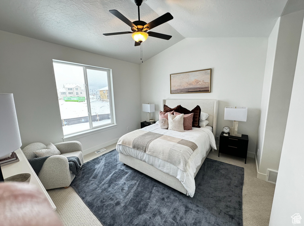 Bedroom featuring dark carpet, vaulted ceiling, and ceiling fan