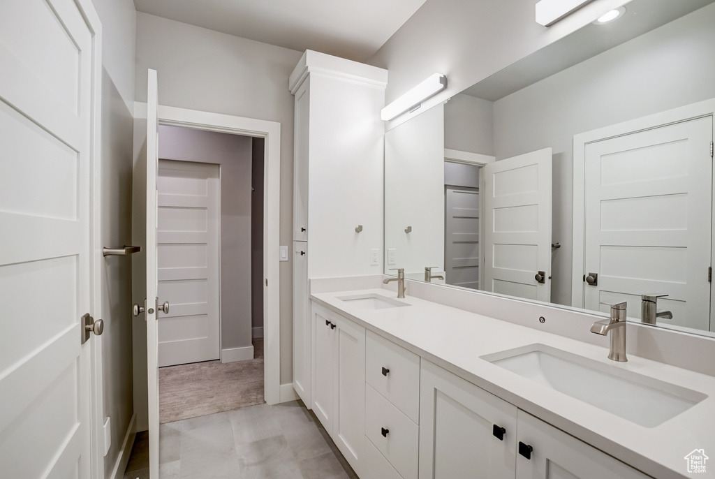 Bathroom featuring dual bowl vanity and tile floors