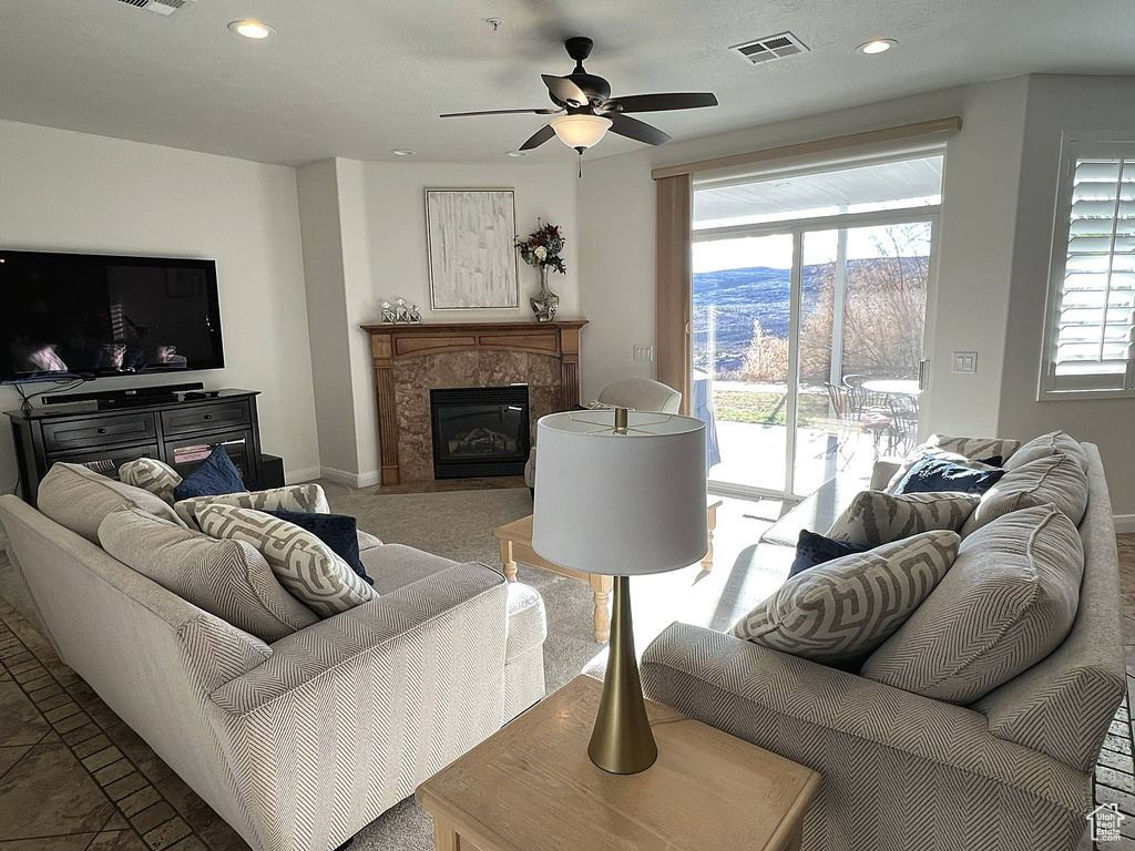 Living room featuring a mountain view, light tile flooring, and ceiling fan