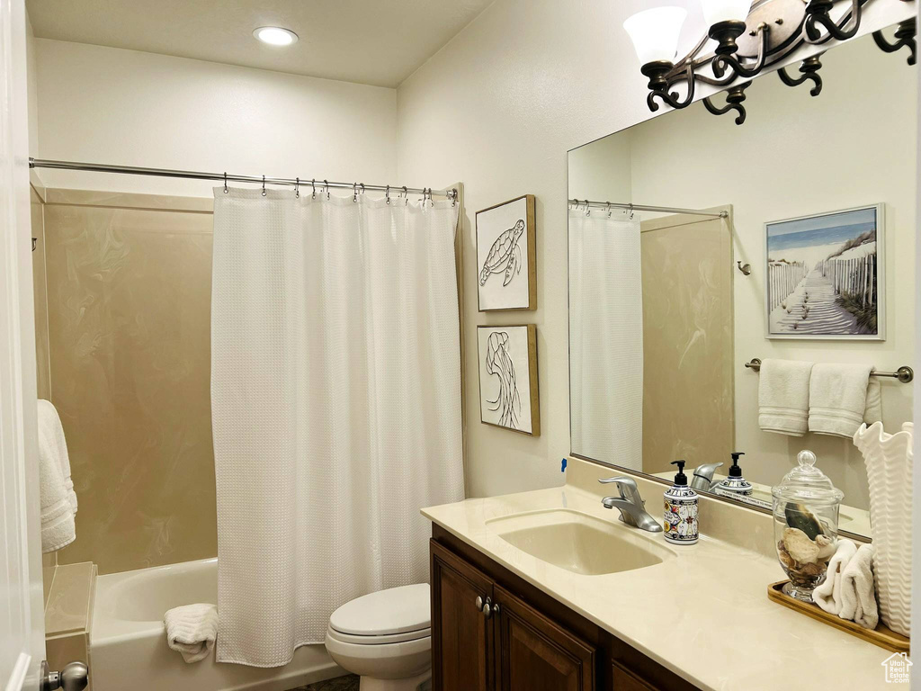 Full bathroom with toilet, vanity, and shower / bath combo