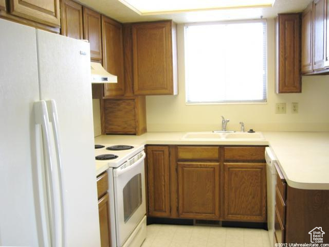 Kitchen featuring sink, plenty of natural light, premium range hood, and white appliances