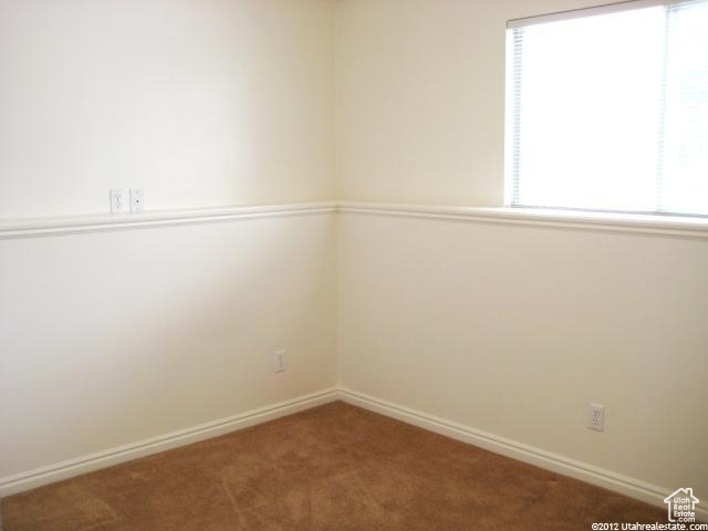Unfurnished room featuring a healthy amount of sunlight and carpet