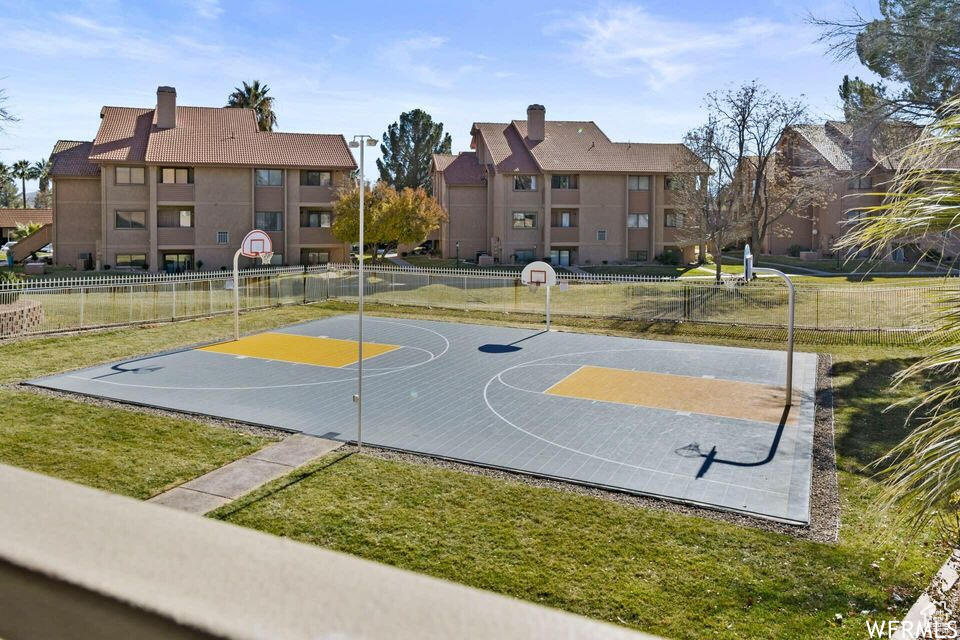 View of basketball court with a yard