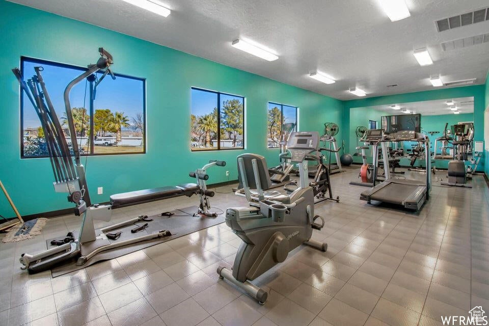 Exercise room with a textured ceiling and light tile floors