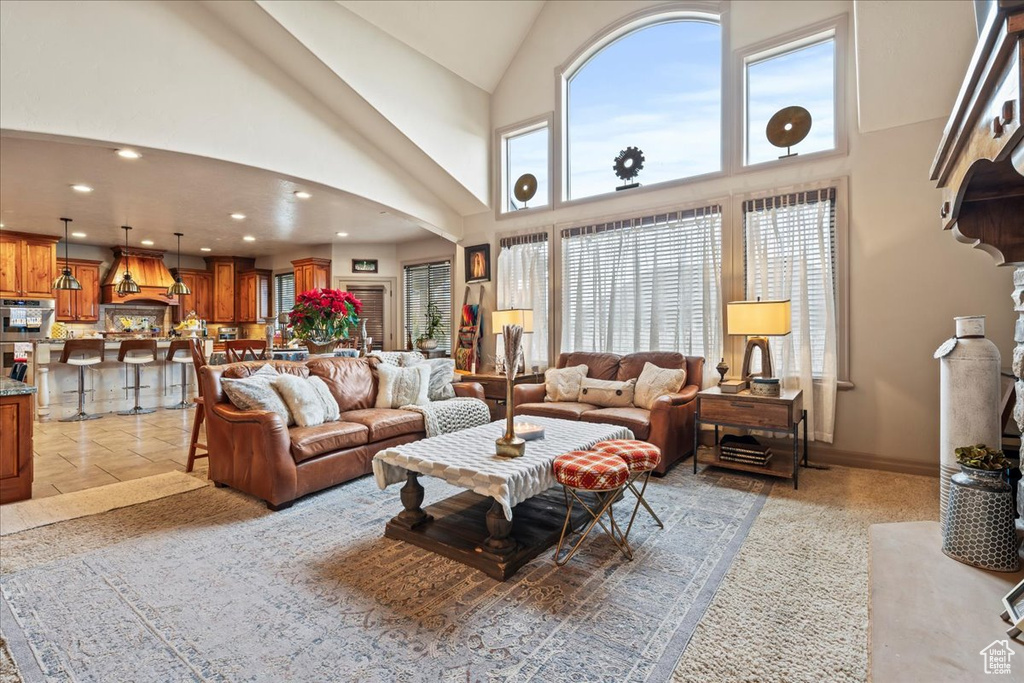 Living room with high vaulted ceiling and light tile floors