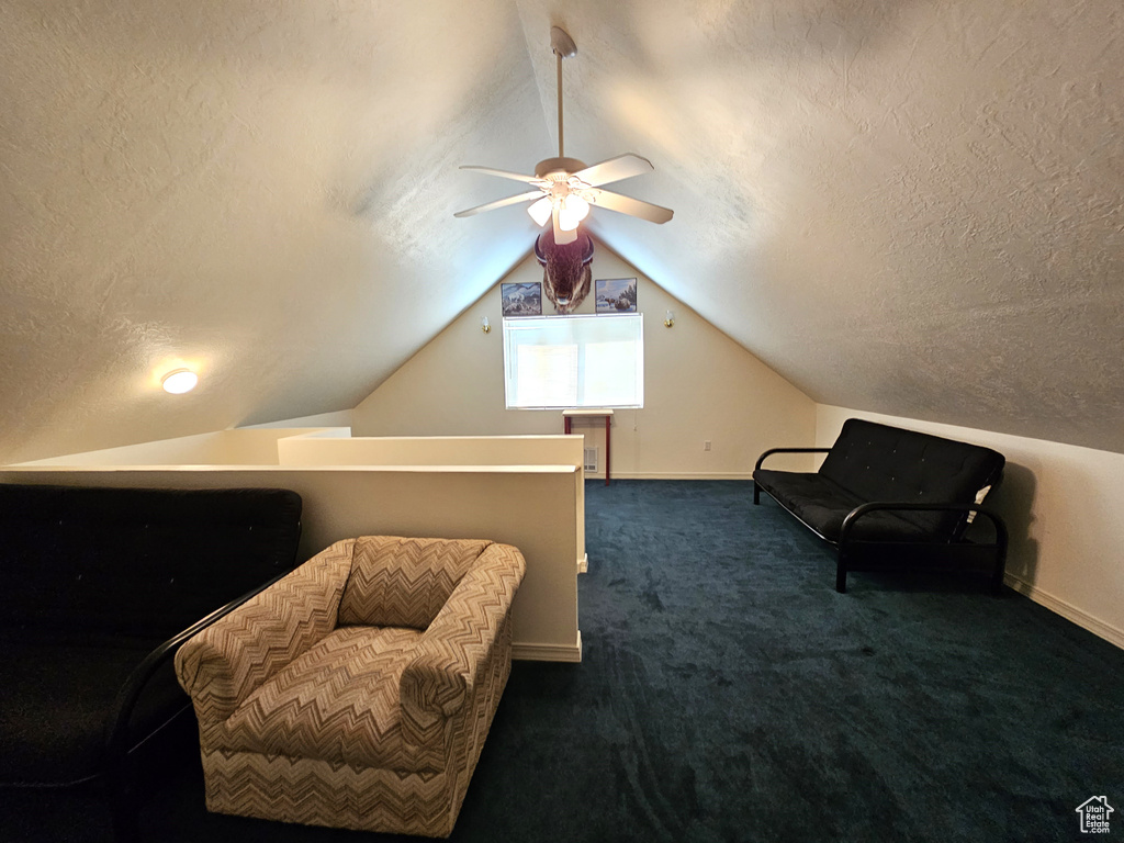 Living area featuring ceiling fan, a textured ceiling, and lofted ceiling