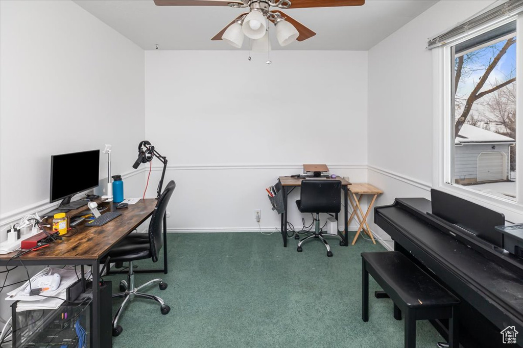 Office featuring dark colored carpet and ceiling fan