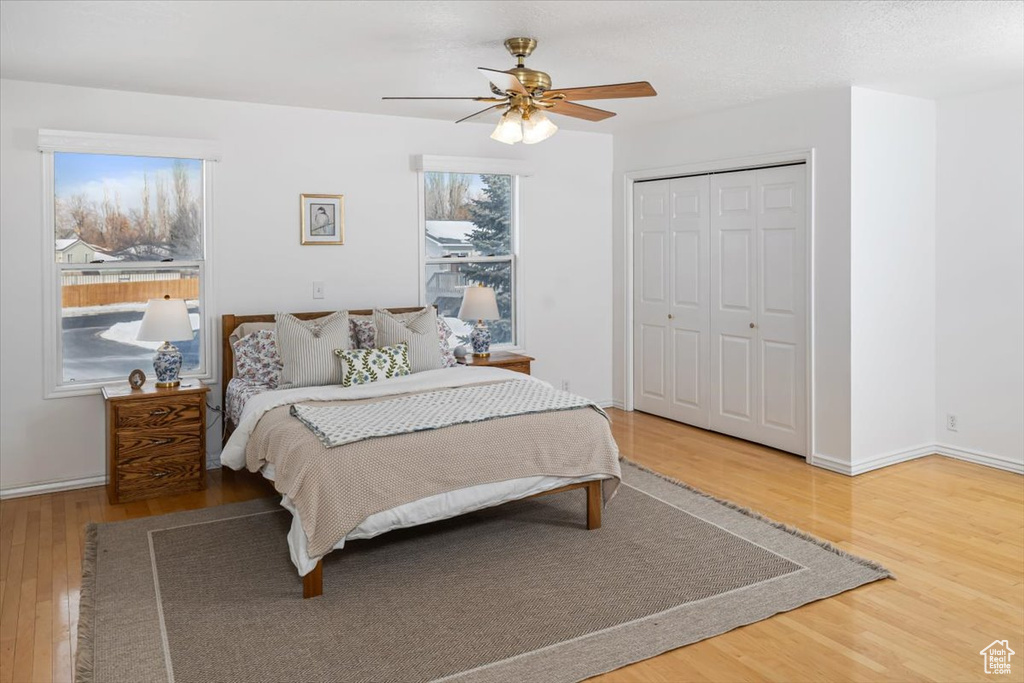 Bedroom with a closet, hardwood / wood-style flooring, and ceiling fan