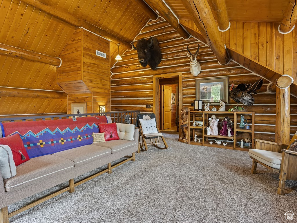 Carpeted living room featuring log walls, beamed ceiling, high vaulted ceiling, and wooden ceiling