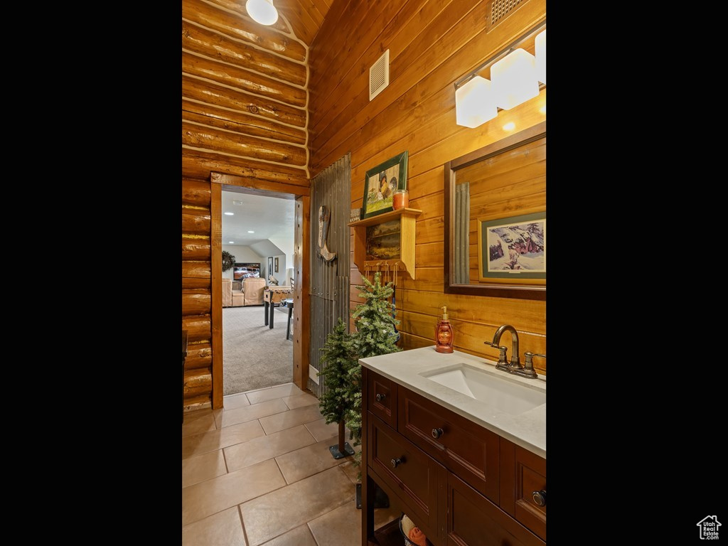 Bathroom with log walls, tile floors, and large vanity
