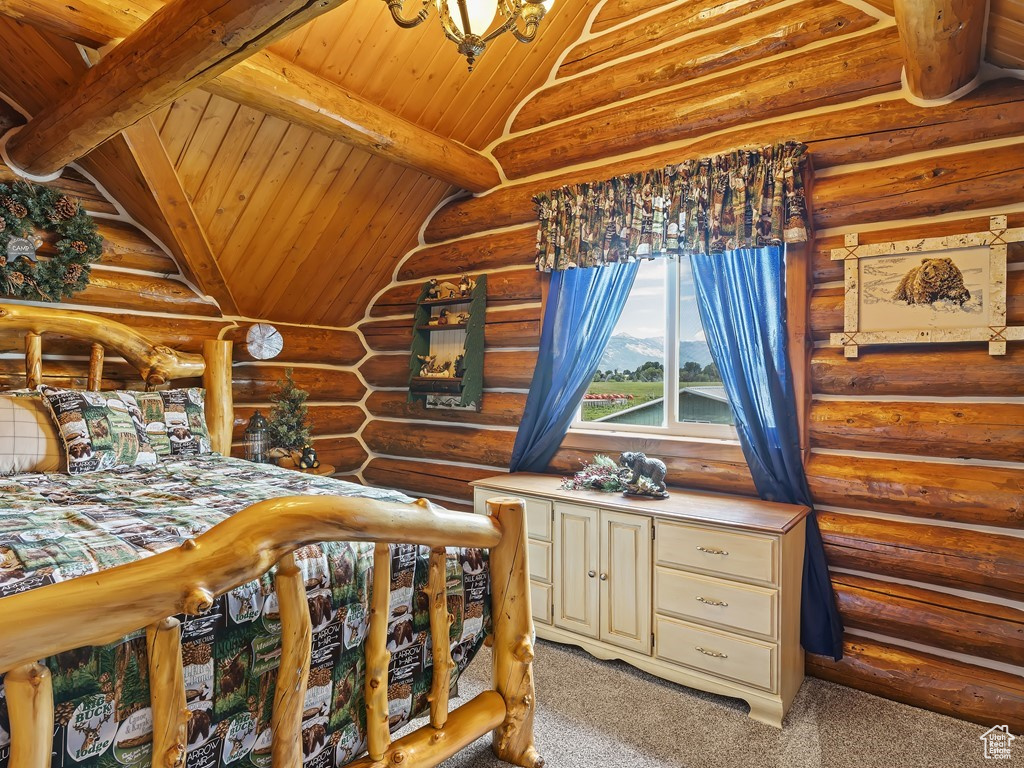 Bedroom with log walls, lofted ceiling with beams, light carpet, and wooden ceiling
